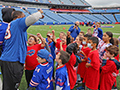  Group of students gather together in a huddle with Bills players